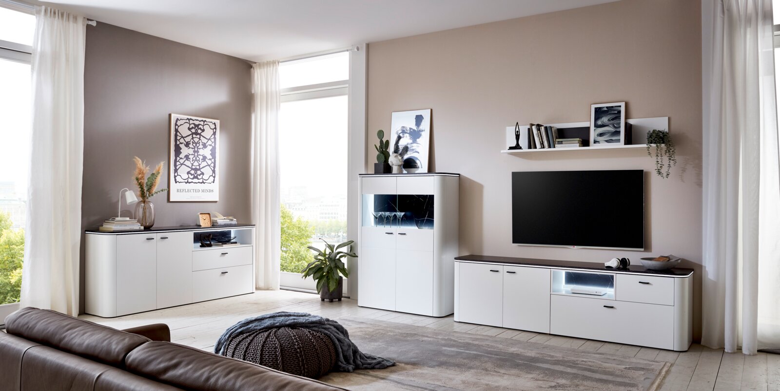 Moderne Wohnzimmer-Wandkombination in Weiß mit Schränken, Regalen und TV-Bereich, seitliche Perspektive