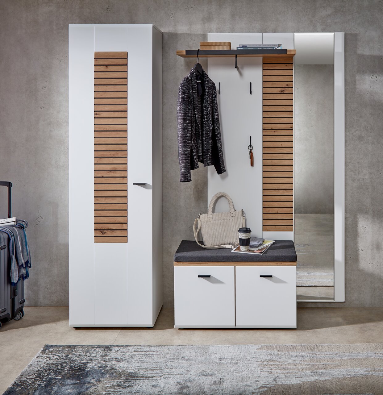 Moderne Garderobenkombination mit weißem Schrank, Garderobenpaneel und Spiegel in Frontalansicht. Enthält hölzerne Akzente und eine Sitzbank mit Stauraum.