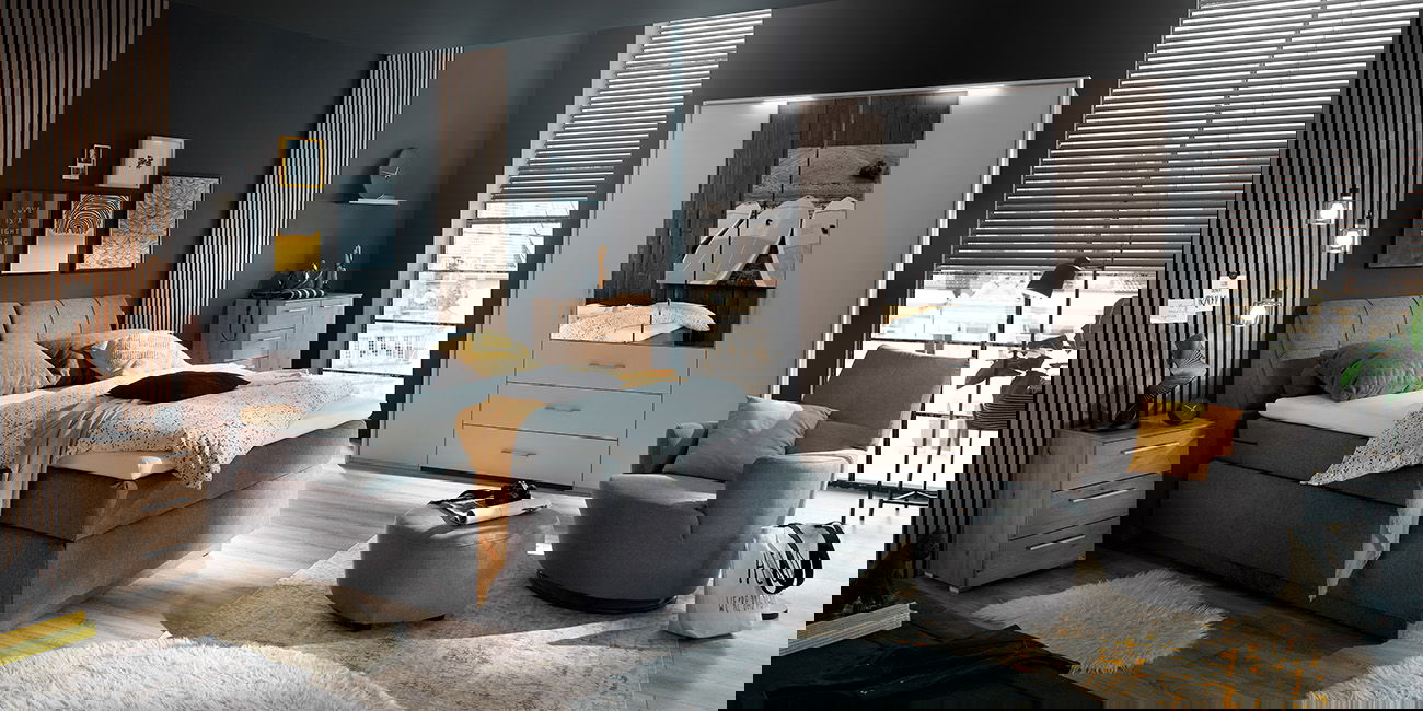 Ein Schlafzimmer mit dunkelgrauem Bett und weißen Kleiderschrank.