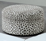 Runder, gepolsterter Pouf/Hocker mit Leopardenmuster in Weiß und Grau, freigestellt auf grauem Boden, Ansicht schräg von vorne leicht von oben