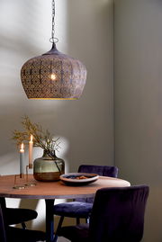 Orientalische Hängeleuchte mit filigranem Muster, seitliche Perspektive, über einem Esstisch mit Dekoration.