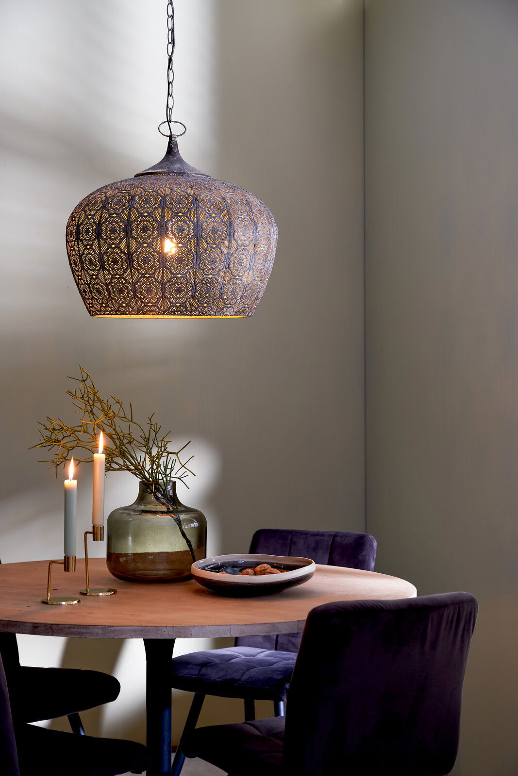 Orientalische Hängeleuchte mit filigranem Muster, seitliche Perspektive, über einem Esstisch mit Dekoration.