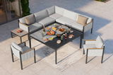 Moderne Lounge-Möbelgruppe auf einer Terrasse, bestehend aus einem Ecksofa, zwei Sesseln und einem großen Tisch, von oben betrachtet.