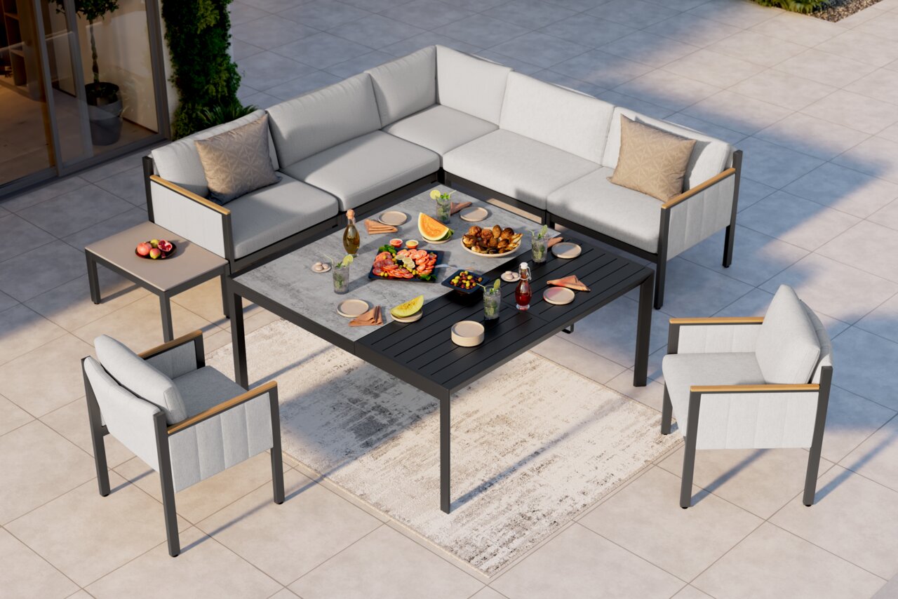 Moderne Lounge-Möbelgruppe auf einer Terrasse, bestehend aus einem Ecksofa, zwei Sesseln und einem großen Tisch, von oben betrachtet.