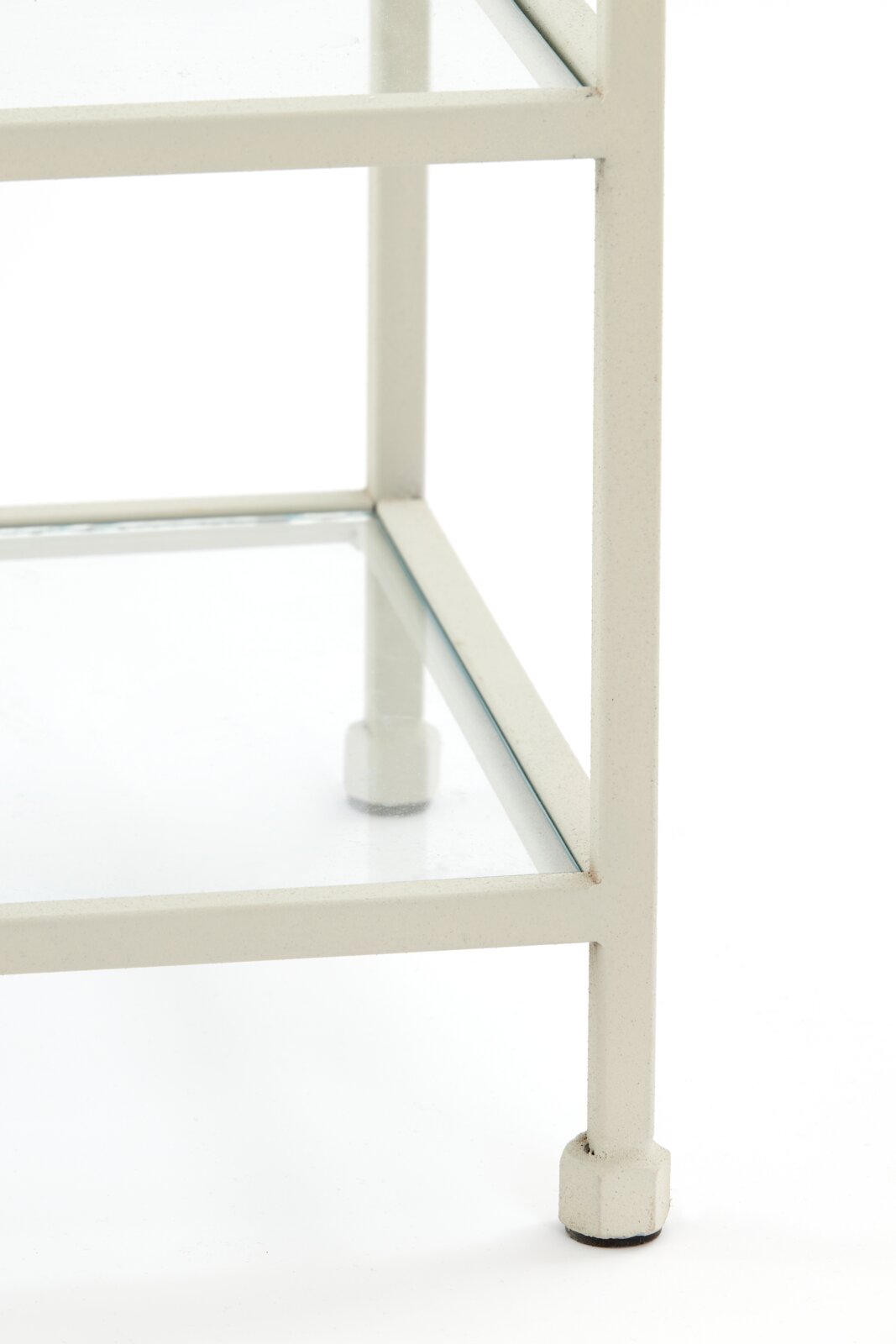 Close-up van een witte consoletafel met glazen blad, gezien van rechtsonder.