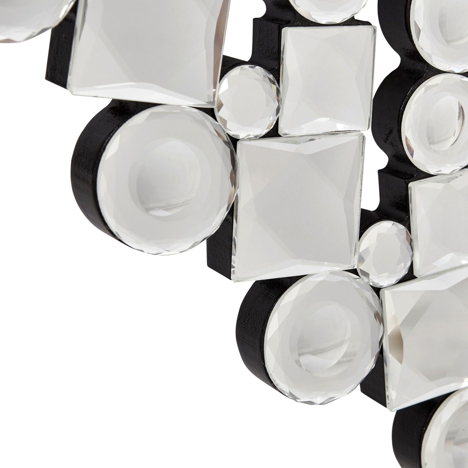 Nahaufnahme eines dekorativen Spiegels mit facettierten, runden und quadratischen Glaselementen auf schwarzem Hintergrund, perspektivisch von der Seite aufgenommen.