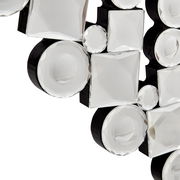 Nahaufnahme eines dekorativen Spiegels mit facettierten, runden und quadratischen Glaselementen auf schwarzem Hintergrund, perspektivisch von der Seite aufgenommen.