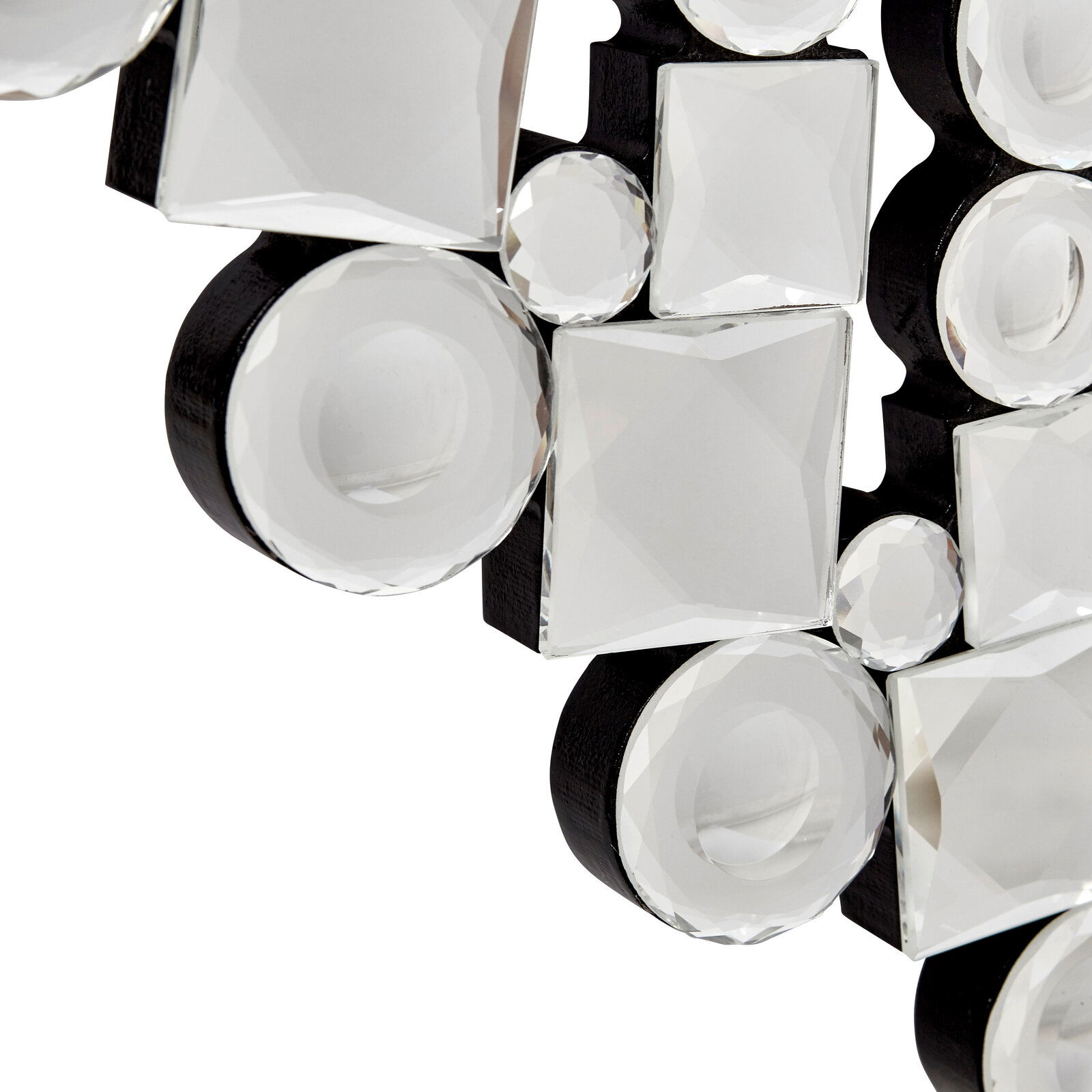 Nahaufnahme eines dekorativen Spiegels mit facettierten, runden und quadratischen Glaselementen auf schwarzem Hintergrund, perspektivisch von der Seite aufgenommen.