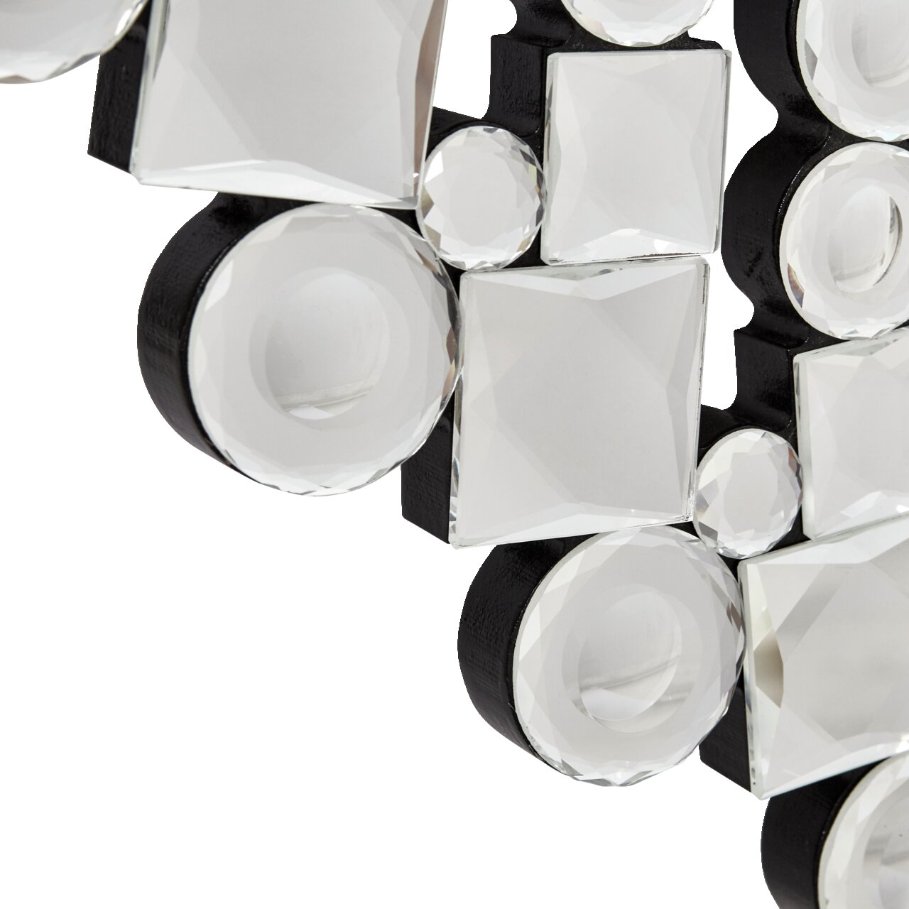 Nahaufnahme eines dekorativen Spiegels mit facettierten, runden und quadratischen Glaselementen auf schwarzem Hintergrund, perspektivisch von der Seite aufgenommen.