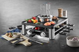 Frontale Ansicht der Lumero Gourmet Station 3-in-1 mit Grillplatte, Fondue-Topf und Raclette-Pfännchen, umgeben von frischen Zutaten und Gewürzen.