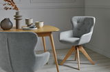 Grauer, gepolsterter Stuhl mit Holzbeinen in einem modernen Esszimmer, seitliche Perspektive
