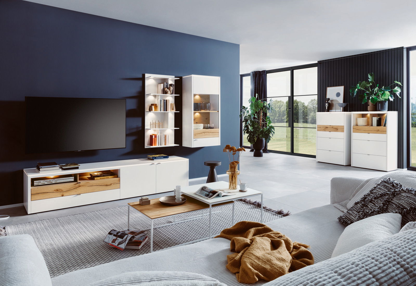 Modernes Wohnzimmer mit Highboard in Weiß und Holzoptik, seitliche Perspektive