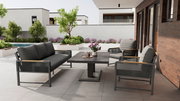 Moderne Loungegarnitur auf einer Terrasse mit Blick auf einen Garten, bestehend aus einem Tisch, einem Sofa und Sesseln in stilvollem Design.
