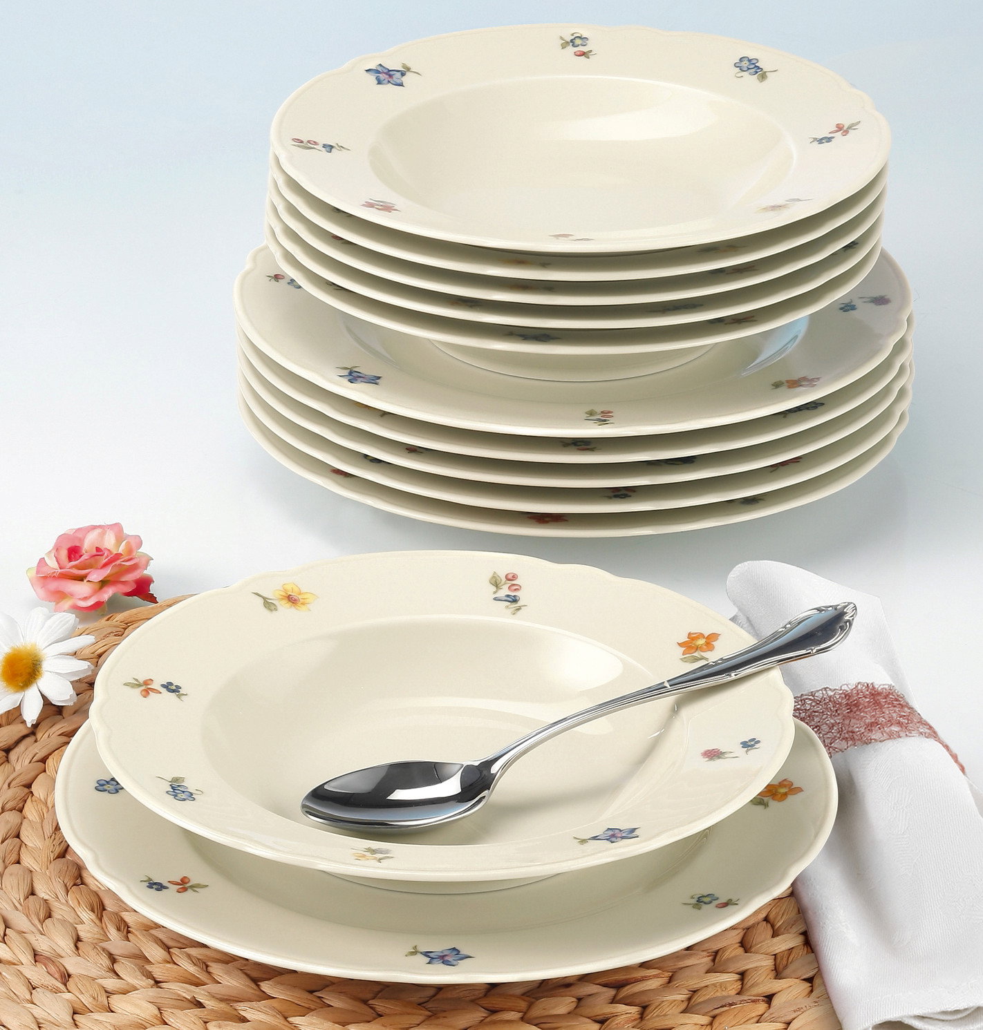 Seltmann Weiden Tafel Set 12-tlg MARIE LUISE Tafelset Marie-Luise 12-tlg. mit floralem Muster, gestapelte Teller in Seitenansicht, dekoriert mit Löffel und Serviette.