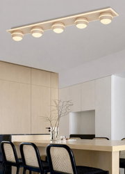 Moderne led-plafondlamp met vier ronde lampen, van onderaf gezien in een stijlvolle eetkamer.