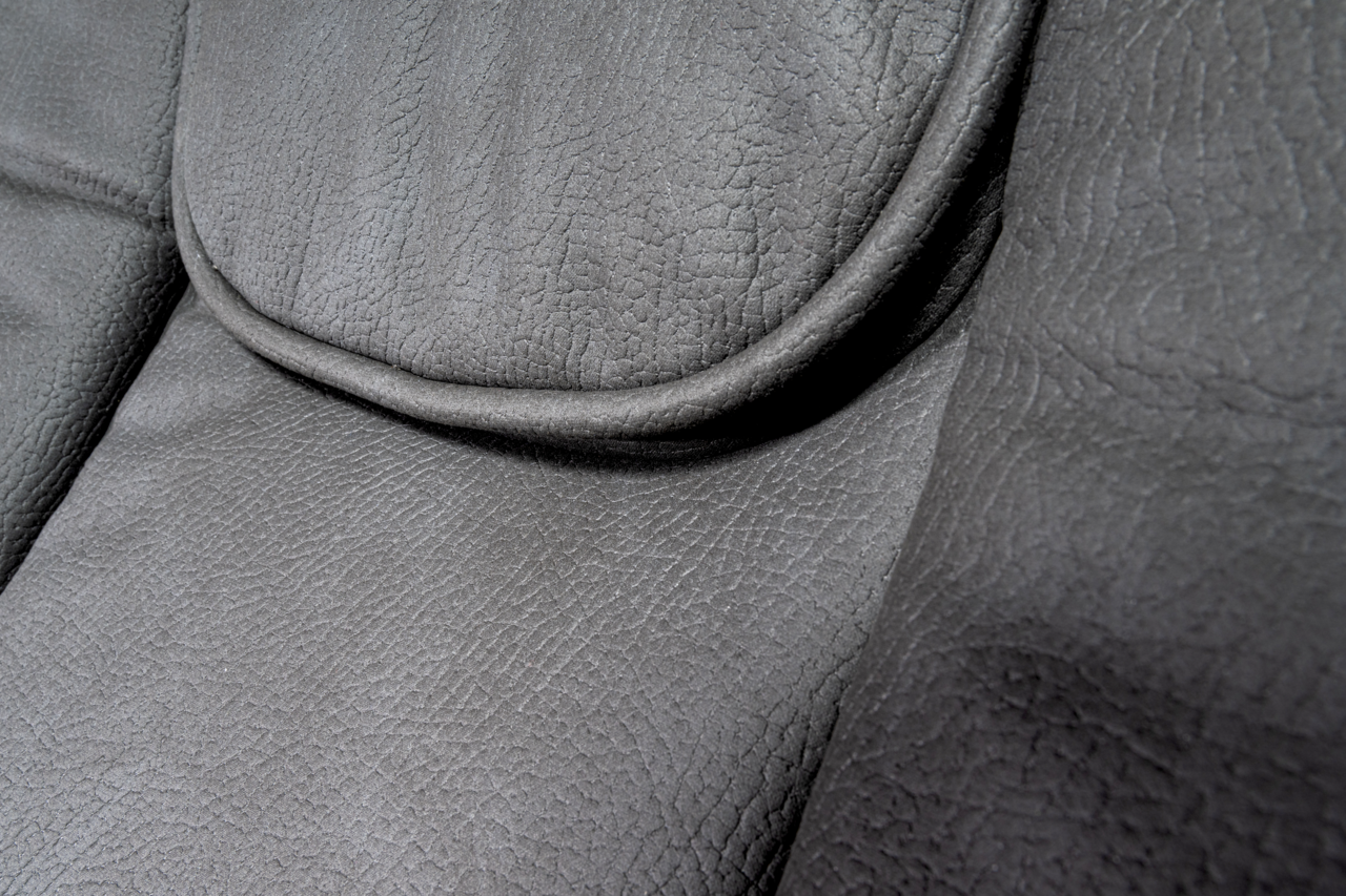 Nahaufnahme der grauen Lederpolsterung eines Chefsessels, Detailansicht der Sitzfläche