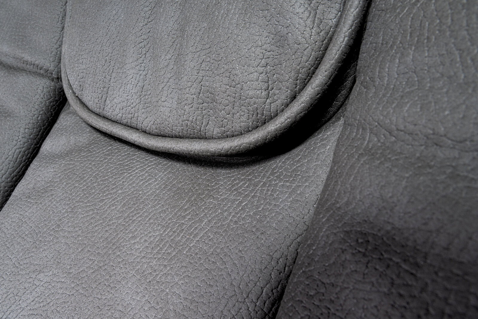 Nahaufnahme der grauen Lederpolsterung eines Chefsessels, Detailansicht der Sitzfläche