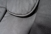 Nahaufnahme der grauen Lederpolsterung eines Chefsessels, Detailansicht der Sitzfläche