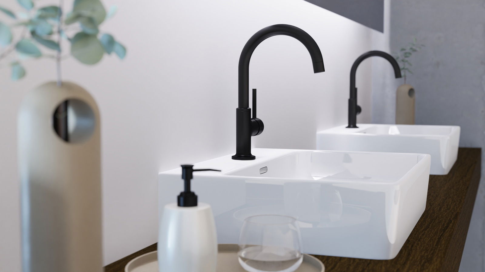 Moderne schwarze Waschtischarmatur in seitlicher Perspektive, montiert auf einem weißen Waschbecken mit Holzunterlage, im Hintergrund eine weitere Armatur und Dekoration.