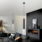 Moderne schwarze zylindrische Pendelleuchte mit direktem Lichtkegel nach unten, in einem Wohnzimmer montiert, Ansicht aus leicht niedriger Perspektive nach oben