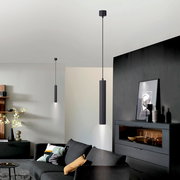 Moderne schwarze zylindrische Pendelleuchte mit direktem Lichtkegel nach unten, in einem Wohnzimmer montiert, Ansicht aus leicht niedriger Perspektive nach oben