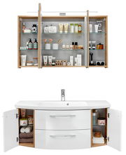 Badezimmerkombination mit Spiegelschrank und Waschbeckenunterschrank, frontal fotografiert. Der Spiegelschrank zeigt geöffnete Türen mit Pflegeprodukten, der Unterschrank hat offene Türen mit Handtüchern und Pflegeartikeln.