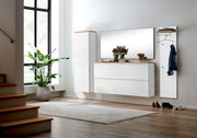 Modernes, wandhängendes Flurmöbel-Set in Weiß Hochglanz mit Holzablagen, großem Spiegel, Hängeschrank und Garderobenpaneel mit Haken und Kleiderbügel, frontal in leichter Schrägansicht von links im hellen Eingangsbereich