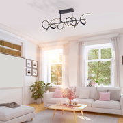 Moderne Deckenleuchte CURLS in einem hellen Wohnzimmer, von unten betrachtet, mit geschwungenem Design und schwarzem Finish.