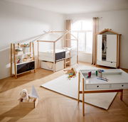 Kinderzimmer mit Hausbett, Kleiderschrank, Bücherregal und Schreibtisch in heller, moderner Einrichtung. Perspektive von vorne.