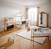 Kinderzimmer mit Hausbett, Kleiderschrank, Bücherregal und Schreibtisch in heller, moderner Einrichtung. Perspektive von vorne.