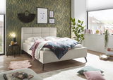 Modernes Polsterbett in einem stilvoll eingerichteten Schlafzimmer, seitliche Perspektive