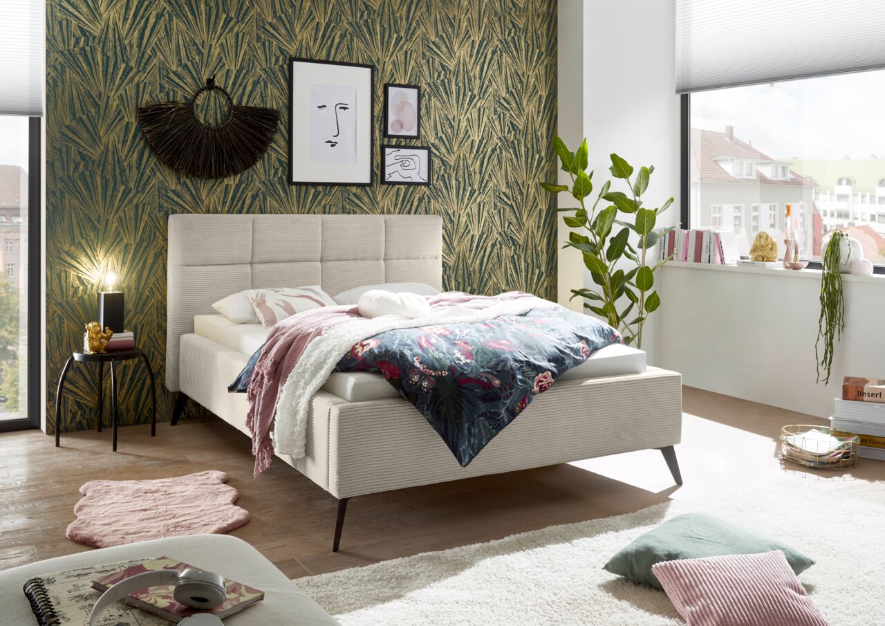 Modernes Polsterbett in einem stilvoll eingerichteten Schlafzimmer, seitliche Perspektive