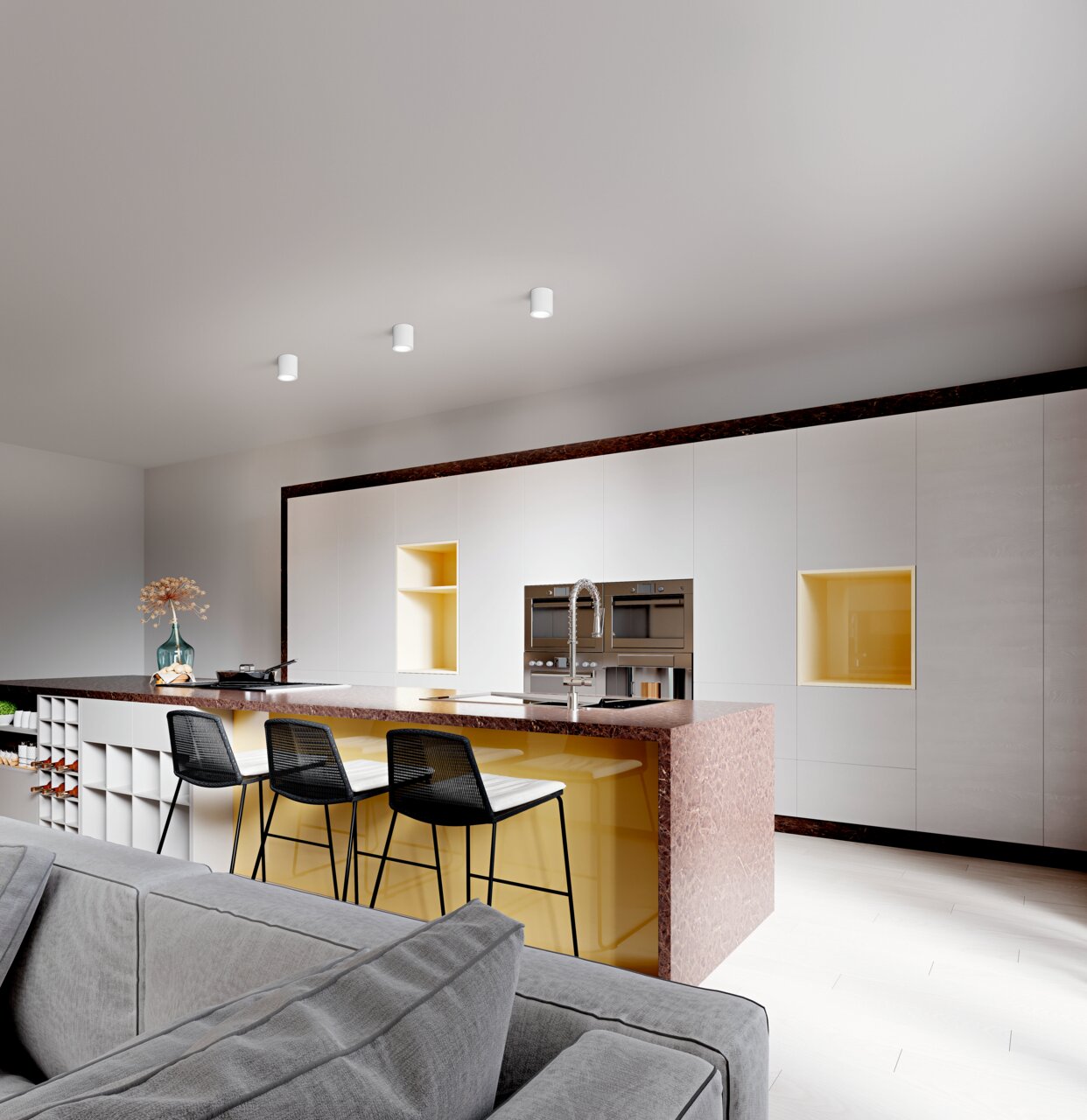 Moderne keuken met drie witte inbouwspots aan het plafond, die zorgen voor een stijlvolle verlichting boven een kookeiland met gele accenten. Aanzicht vanaf de zijkant van de keuken.