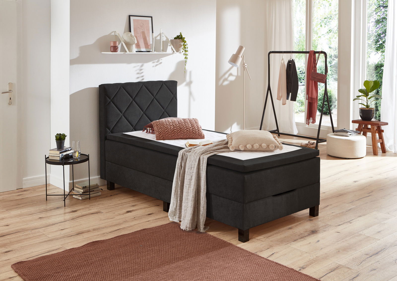 Modernes Boxbett in einem hellen Schlafzimmer, seitliche Perspektive, mit dekorativen Kissen und Decke.