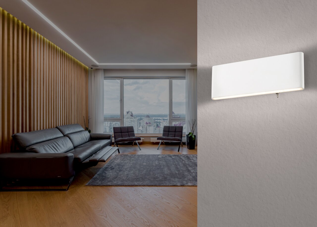 Moderne weiße Wandleuchte aus Aluminium, seitliche Perspektive, montiert in einem stilvollen Wohnzimmer mit großen Fenstern und eleganter Einrichtung.
