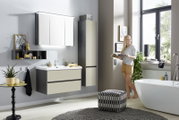 Moderne badkamercombinatie met wastafel, spiegelkast en hoge kast in een stijlvolle badkamer, gezien vanaf de zijkant.