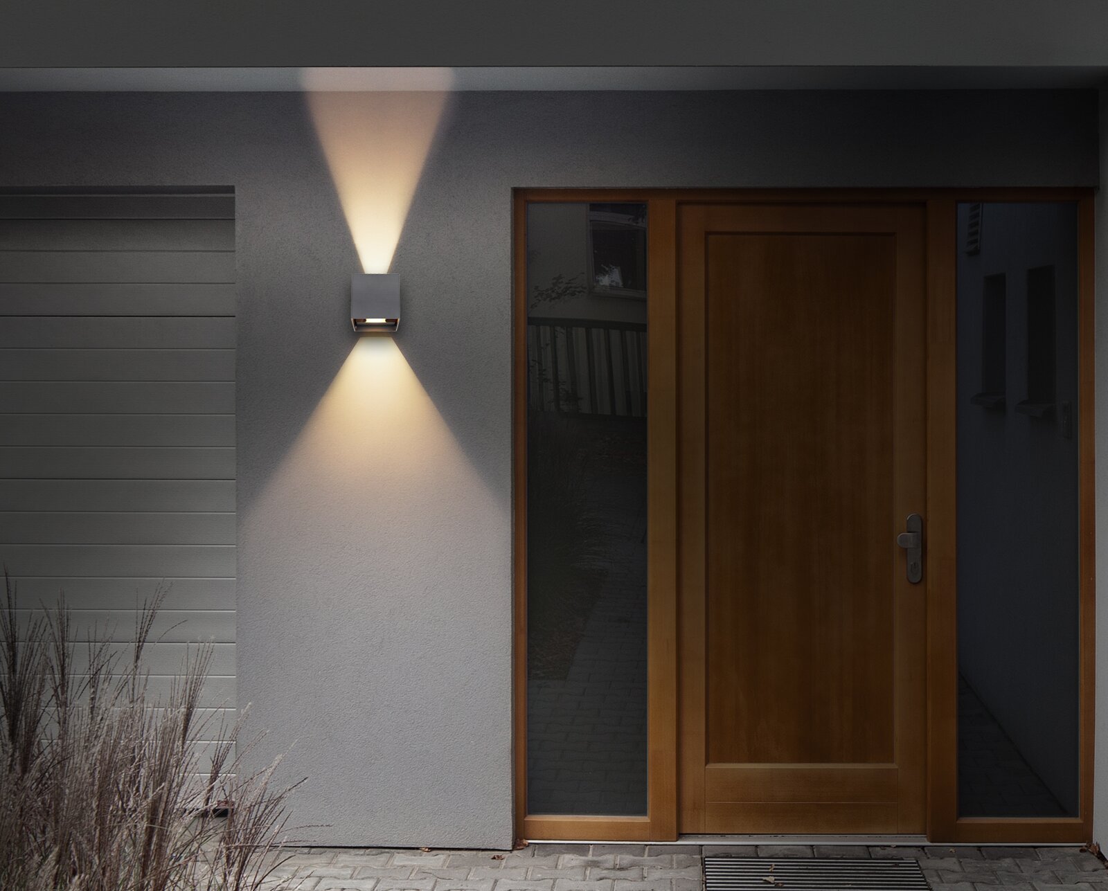 Moderne Außenleuchte an einer Hauswand neben einer Holztür, mit Lichtstrahlen nach oben und unten, frontale Perspektive.