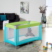 Reisebett in einem modernen Wohnzimmer, seitliche Perspektive, mit grünem und türkisfarbenem Design, gefüllt mit einem Plüschtier.