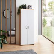 Moderner XL-Schuhschrank in Weiß mit Holzrahmen, frontal fotografiert, in einem hellen Raum mit Pflanzen und großem Fenster.