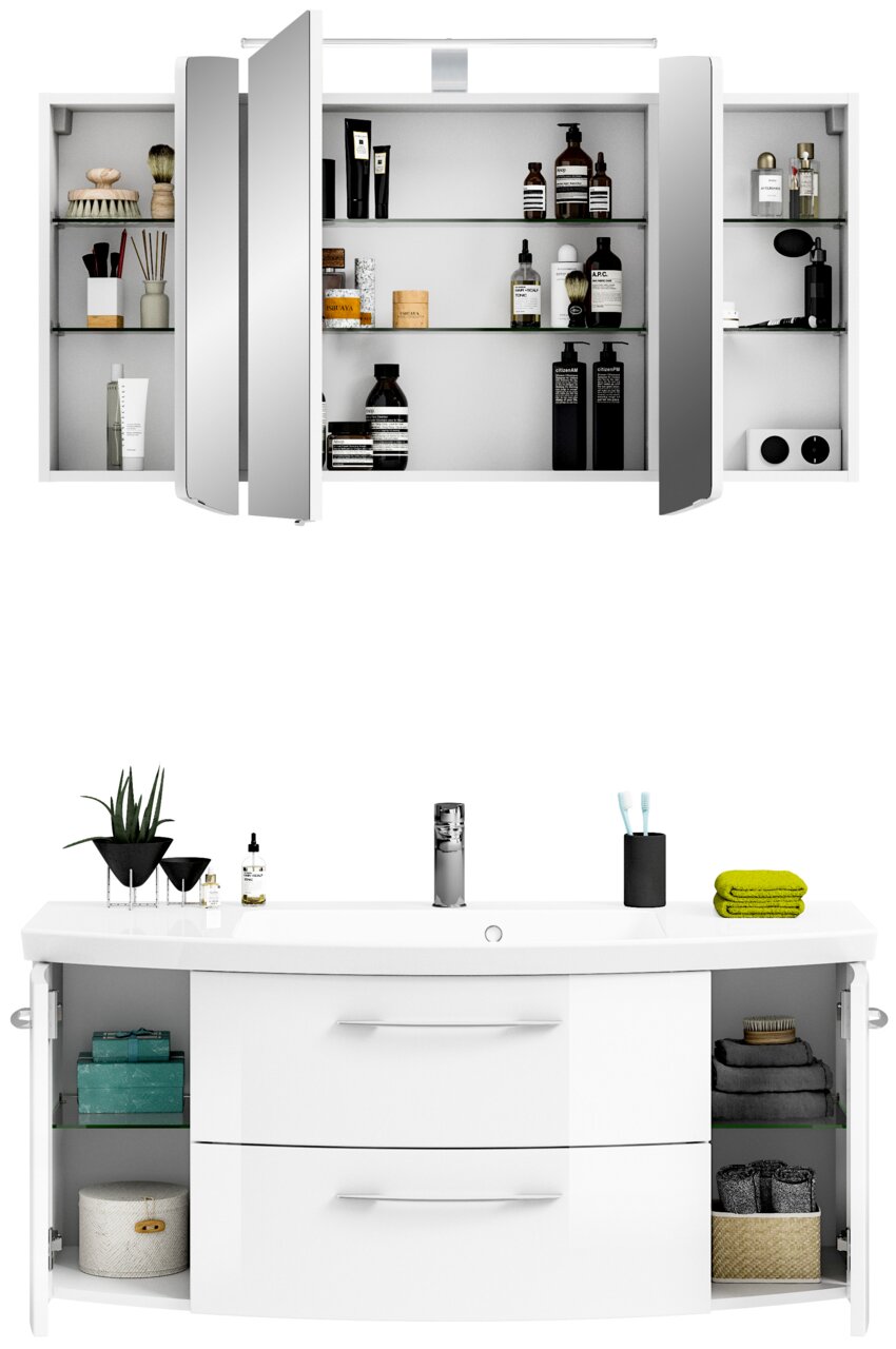 Moderne Badkombination mit Spiegelschrank und Waschbeckenunterschrank, frontal abgebildet. Der Spiegelschrank ist geöffnet und zeigt diverse Pflegeprodukte. Der Waschbeckenunterschrank hat zwei Schubladen und seitliche Fächer mit Handtüchern und Dekoratio