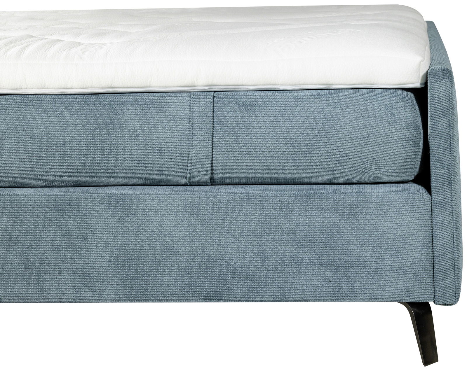 Nahaufnahme eines blauen Boxspringbetts mit weißem Topper, seitliche Perspektive