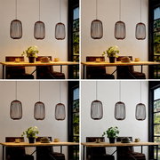 Drei moderne Hängeleuchten mit zylindrischem Drahtschirm in Schwarz/Kupfer hängen über einem Holztisch im Essbereich, frontale Perspektive auf die Leuchten und den Tisch.