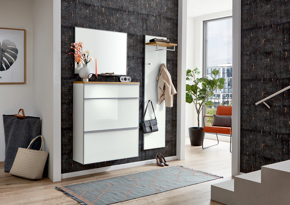 VOSS Garderoben-Set 4-tlg. VORTINA Modernes Flur-Set mit weißer, wandhängender Kommode und großem Spiegel sowie Garderobenpaneel mit Ablage und Haken vor dunkler Wand, seitliche Frontansicht in einem hellen Eingangsbereich.