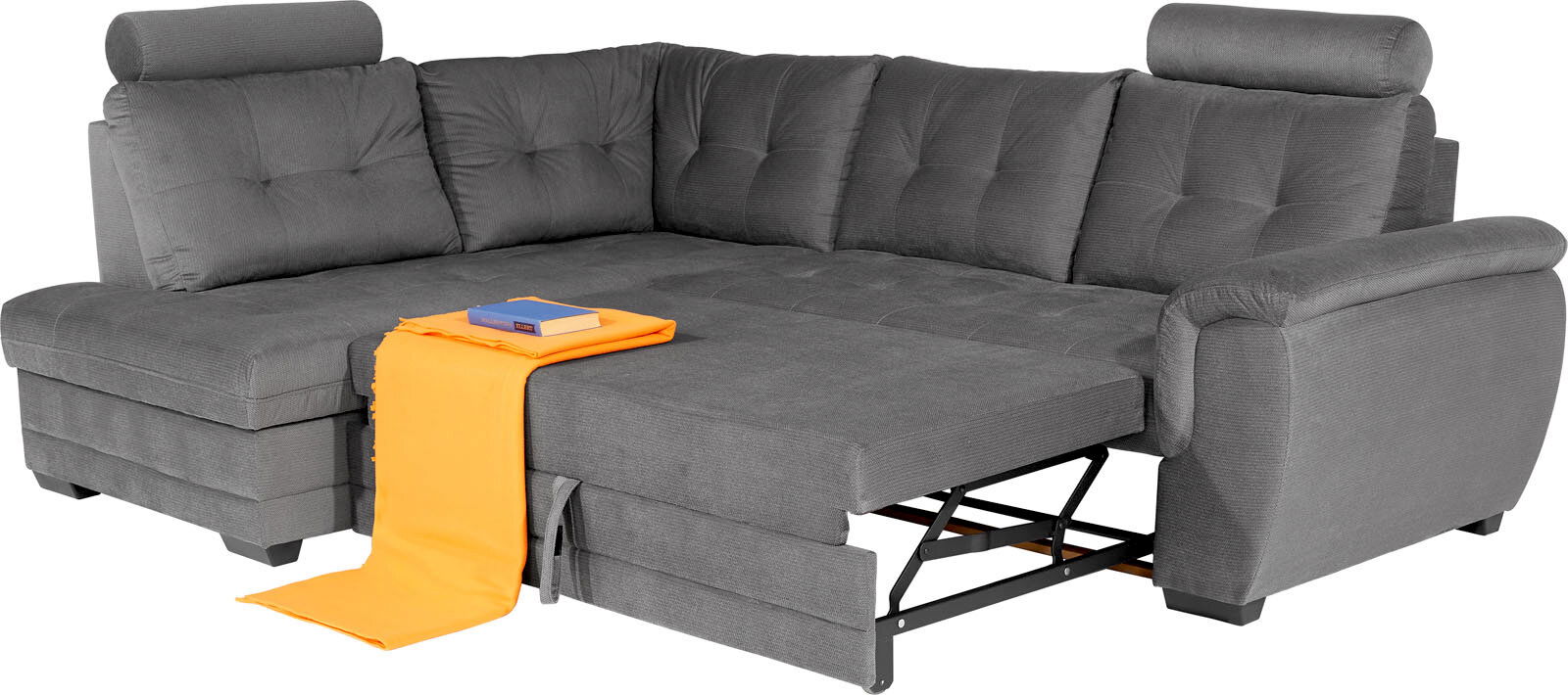 Graue Eckcouch mit verstellbarem Kopfteil und ausziehbarer Liegefläche, von vorne betrachtet. Ein orangefarbenes Tuch und ein Buch liegen auf der Couch.