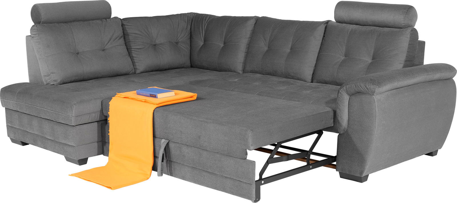 Graue Eckcouch mit verstellbarem Kopfteil und ausziehbarer Liegefläche, von vorne betrachtet. Ein orangefarbenes Tuch und ein Buch liegen auf der Couch.