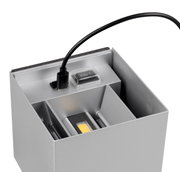Nahaufnahme einer silbernen Akku-Wandleuchte TALENT mit USB-Ladekabel und Schalter.
