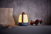 Stimmungsvolle Tischleuchte mit Holzgriff, seitliche Perspektive, neben einer Dekofigur und Naturmaterialien aufgestellt.