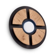 Runde Designleuchte mit schwarzem Metallrahmen, vier Segmenten aus naturbelassenem Holz und zentralem Lichtaustritt, aus leicht schräger Frontperspektive auf weißem Hintergrund