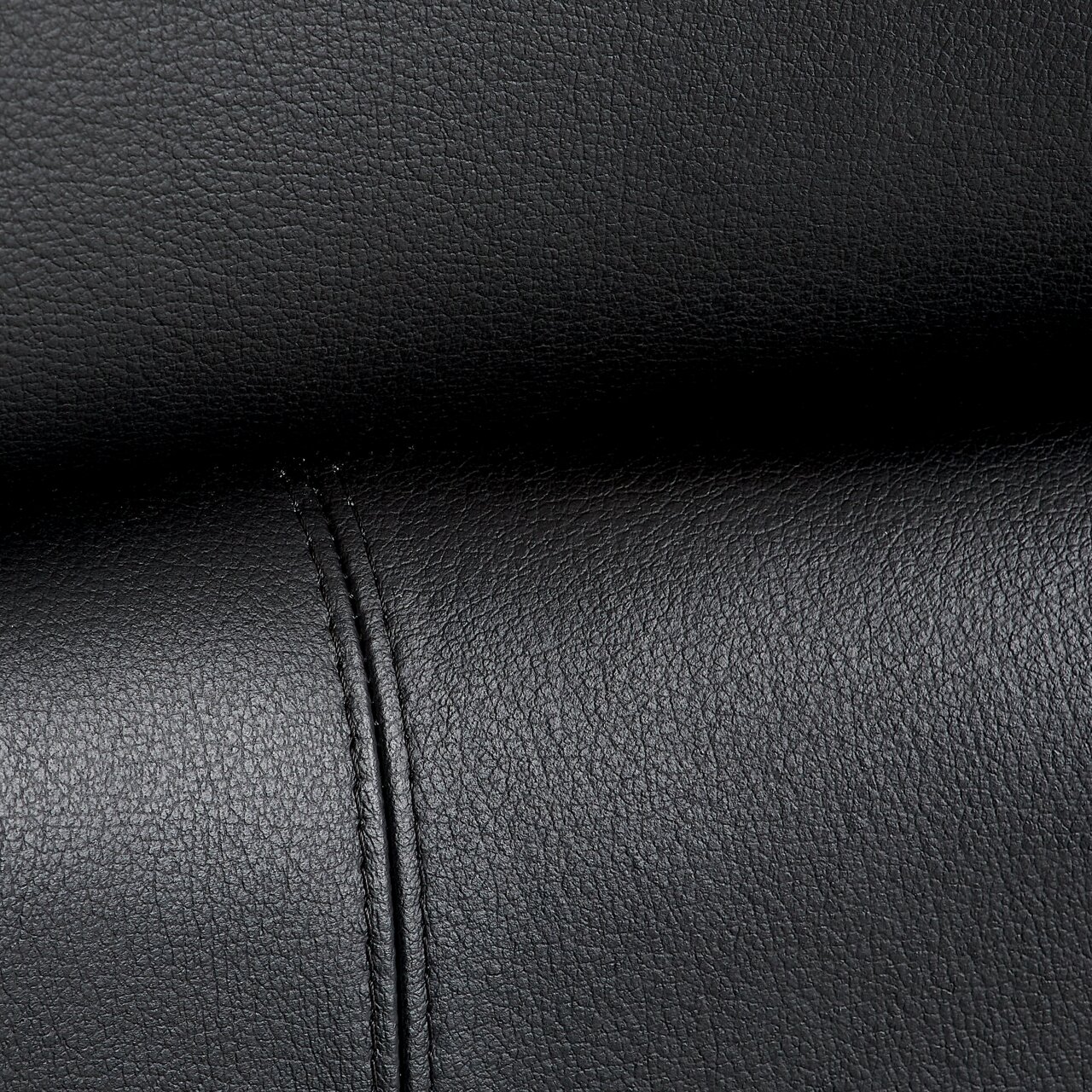 Nahaufnahme der schwarzen Lederpolsterung eines Chefsessels mit sichtbaren Nähten.