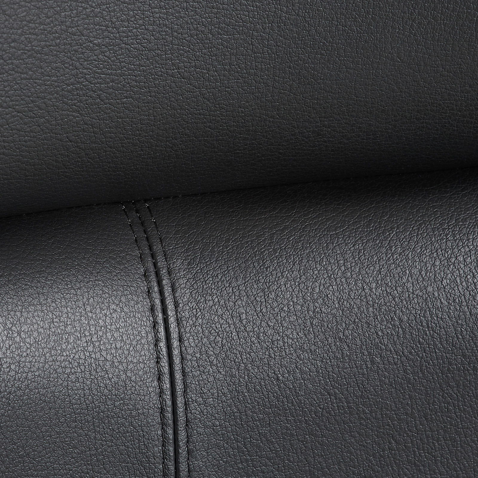 Nahaufnahme der schwarzen Lederpolsterung eines Chefsessels mit sichtbaren Nähten.